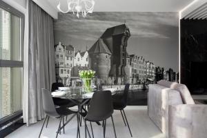 ein Esszimmer mit einem schwarz-weißen Bild einer Stadt in der Unterkunft Elite Apartments Granaria Luxury in Danzig