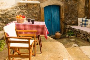 a table with a blue door and a table with fruit on it at Ktima Aikaterini in Séllai