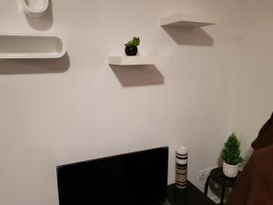 a room with a computer monitor and shelves on the wall at Appartement moderne Roanne in Roanne