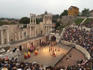 een menigte mensen die naar een parade kijken voor een gebouw bij Къща Стария град in Plovdiv