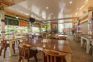 a restaurant with wooden tables and chairs in it at RedDoorz Plus @ Setiabudi Medan 4 in Sunggal