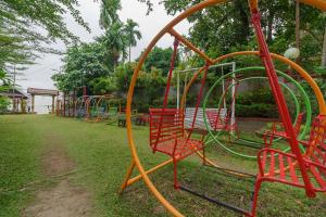 ein leerer Spielplatz mit roten Stühlen in einem Park in der Unterkunft RedDoorz Plus @ Setiabudi Medan 4 in Sunggal