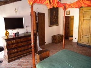 ein Schlafzimmer mit einem Himmelbett und einem TV in der Unterkunft Cesare Magli & Figli Residenza D'Epoca Luxury Rooms in Molinella