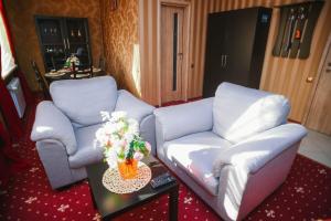 a living room with two couches and a table with flowers at Hotel Complex Druzhba in Buzuluk
