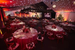 Hurley House Hotel في Hurley: غرفة مليئة بالطاولات والكراسي مع أضواء عيد الميلاد