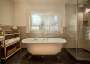 a bathroom with a tub and a glass shower at Hurley House Hotel in Hurley