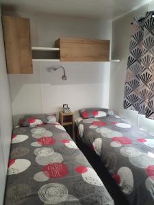 two beds in a small room with at Mobilhome a Gastes in Gastes