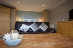 a living room with a couch and a wooden table at Highridge Apartment in Wooler