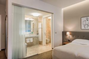 a bedroom with a bed and a bathroom with a shower at Hotel Jakubus in Wilków
