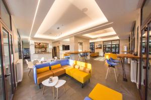 a living room with a couch and tables and chairs at Ligure Residence in Pietra Ligure