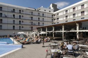 um hotel com pessoas sentadas à volta de uma piscina em Hotel Papi em Malgrat de Mar