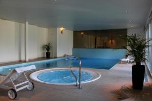 una gran piscina con bañera de hidromasaje en un edificio en Aparthotel Ambassador, en Bellwald