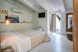 a white bedroom with a bed and a television at B&B Il Colore del mare in Agropoli