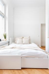 een witte slaapkamer met een groot wit bed bij Pieni Roobertinkatu Small 13 in Helsinki