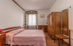 een slaapkamer met een bed, een stoel en een raam bij Bruna in Poreč