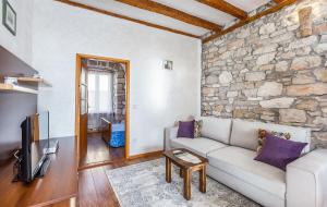 a living room with a couch and a stone wall at Bruna in Poreč