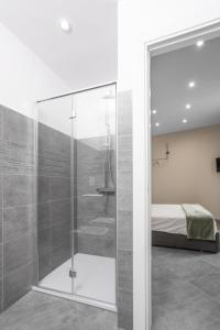 um chuveiro de vidro num quarto com uma cama em VIVERONE LAKE ROOMS em Viverone