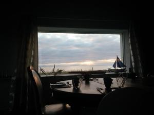 a table with a view of the ocean from a window at Brimslóð Atelier Guesthouse in Blönduós