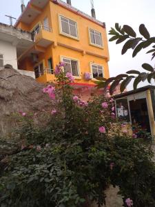 a building with pink flowers in front of it at Madhukunda Homestay in Butwāl