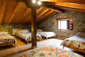 a attic room with three beds and a window at casa de maria in Hazas de Cesto