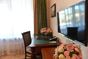 sala de estar con TV y mesa con flores en Danilovskaya Hotel en Moscú