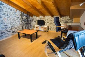 Zimmer mit einem Stuhl, einem Tisch und einem TV in der Unterkunft casa de maria in Hazas de Cesto