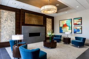 a waiting room with blue chairs and a fireplace at Holiday Inn Chicago North-Evanston, an IHG Hotel in Evanston