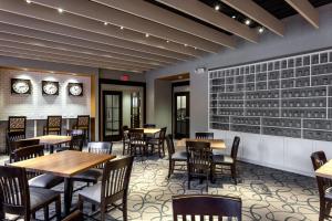 a restaurant with tables and chairs and clocks on the wall at Holiday Inn Chicago North-Evanston by IHG in Evanston +20 photos