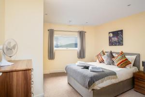 a bedroom with a bed and a window at Coastal City Rooms - Waterfront in Swansea