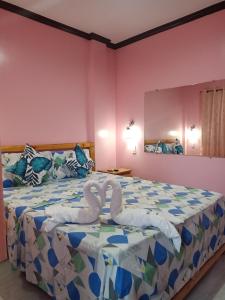 a bedroom with a bed with swans made out of towels at Stella'z guesthouse in Siquijor