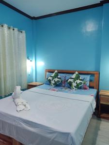 um quarto azul com uma cama com toalhas em Stella'z guesthouse em Siquijor