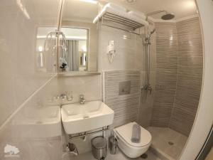 a white bathroom with a sink and a toilet at Costa Point Chios in Chios +28 photos