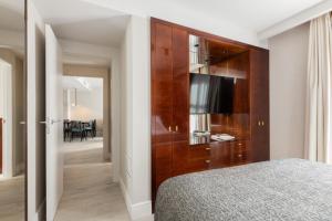 1 dormitorio con un gran armario de madera y TV en Suites Center Barcelona, en Barcelona