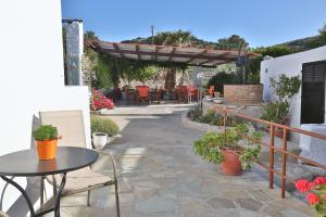 un patio con mesa, sillas y pérgola en Oasis Rooms & Studios in Galissas, en Galissas