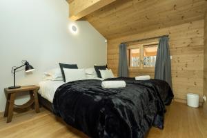 1 dormitorio con 1 cama grande en una habitación de madera en APARTMENT TRABETS 2 - Alpes Travel - LES HOUCHES - sleeps 8, en Les Houches