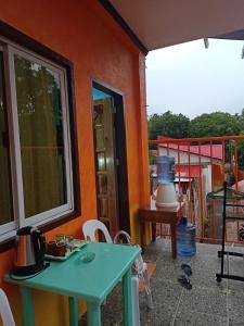 ein Haus mit einem grünen Tisch und einem Balkon in der Unterkunft Stella'z guesthouse in Siquijor