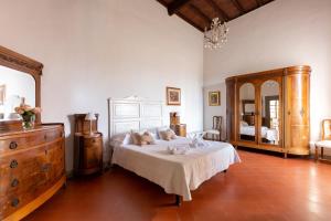 
a bedroom with a bed and a dresser at Castello Vicchiomaggio in Greve in Chianti
