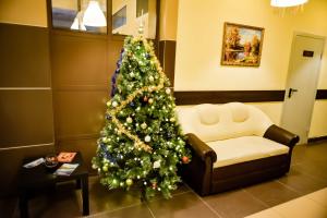 a christmas tree in a waiting room with a couch at Hotel Slavyanka in Nizhny Novgorod