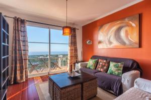 a living room with a couch and a large window at Barcelos Apartment by HR Madeira in Funchal