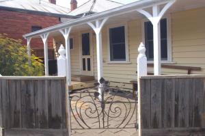 a wooden gate to a house with a porch at Darcy's Cottage on Piper in Kyneton