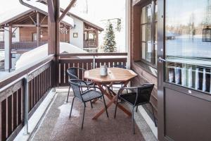 a wooden table and chairs on a balcony at Pointin Vale, Tahko in Kuopio