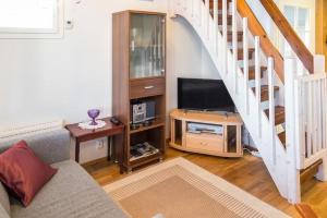 a living room with a television and a staircase at Pointin Vale, Tahko in Kuopio