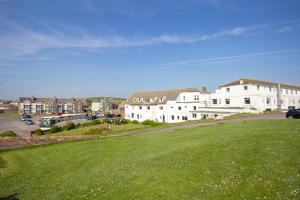 a grassy field with houses and a parking lot at Seacote Hotel in St Bees