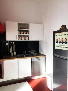 a kitchen with white cabinets and a stove top oven at Espinho Guesthouse - Garden House in Espinho