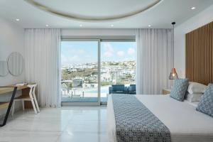 1 dormitorio con cama y vistas a la ciudad en Grand Beach Hotel en Mykonos