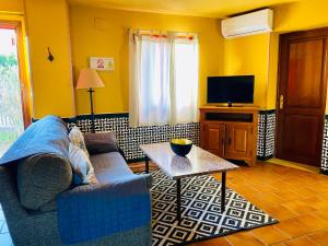 ein Wohnzimmer mit einem Sofa und einem Tisch in der Unterkunft La Estancia Villa Rosillo in Aracena
