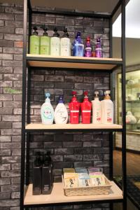 une étagère remplie de nombreuses bouteilles de différentes couleurs dans l'établissement Gomax (Adult Only), à Yokohama