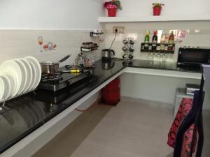 a kitchen with a black counter top and a stove at Coorg Homeland Homestay -With Kitchenette in Madikeri