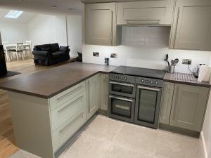 a kitchen with white cabinets and a stove top oven at The Smiddy House in Auchterarder