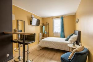 a bedroom with a bed and a table and chairs at Appartements proche Paris Disney in Torcy